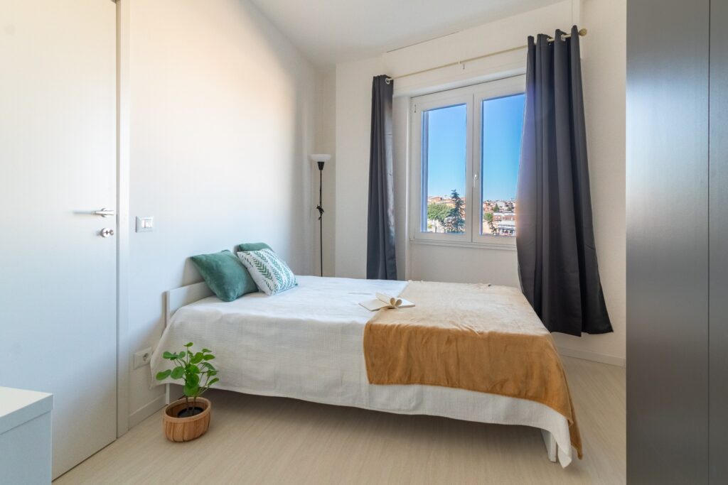 Camera luminosa Casa e Lode con letto, finestra e arredi contemporanei